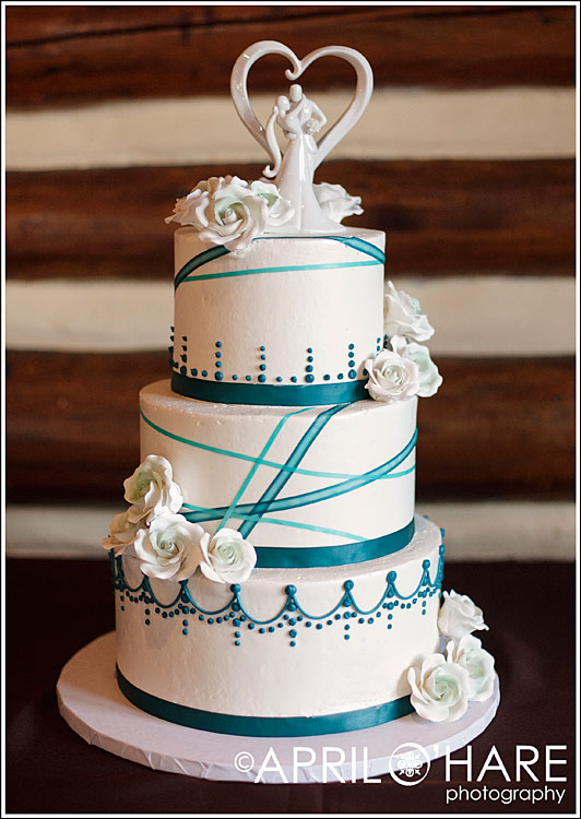Teal and white wedding cake with white rose frosting flowers
