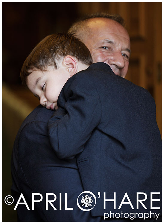 A grandpa holds his grandson who is a ringbearer at his daughter's wedding in Coloado