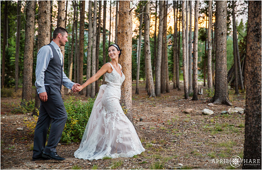 Couple walks through woods at Bluesky Breckenridge at their wedding
