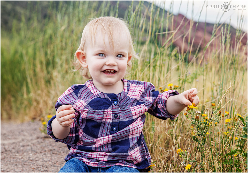 Adorable little girl wearing blue and pink plaid at Colorado family session at Mount Falcon Trailhead in Morrison