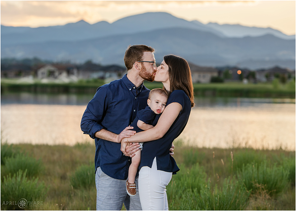 Mom and Dad kiss over their sweet one year old baby boy's head Loveland CO