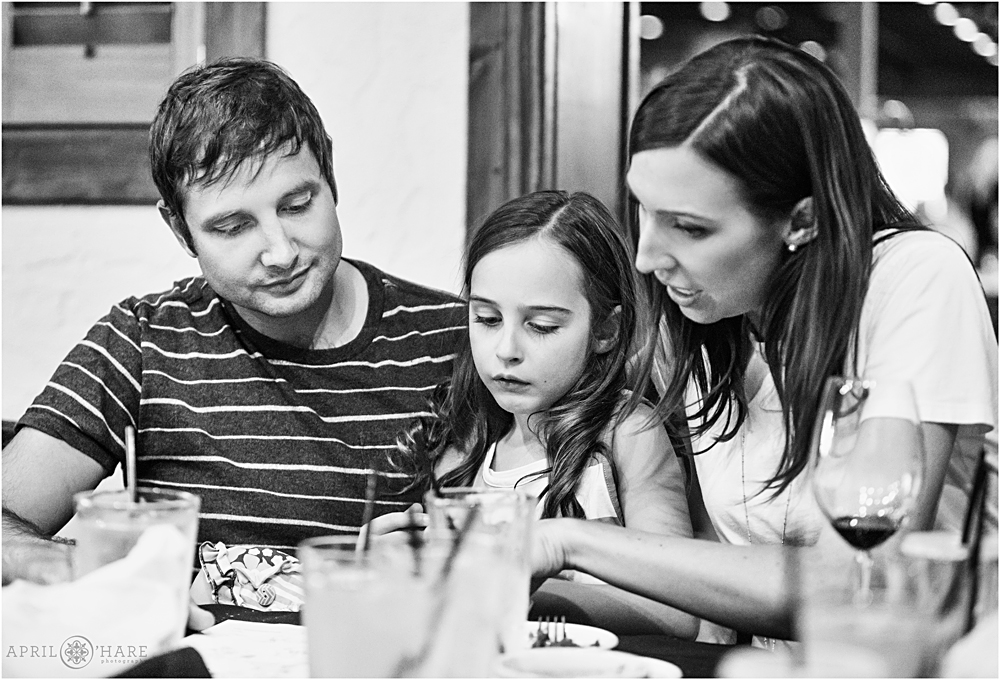 Family looks at an album at a birthday party dinner in Colorado