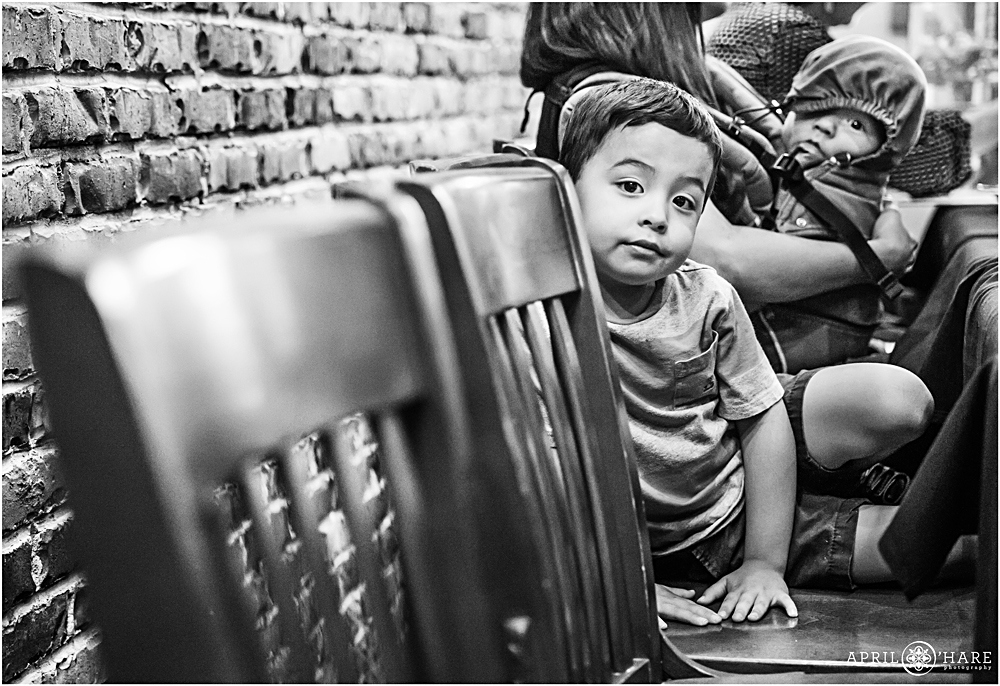 Candid B&W Event Photography of a kid sitting on a chair in a restaurant