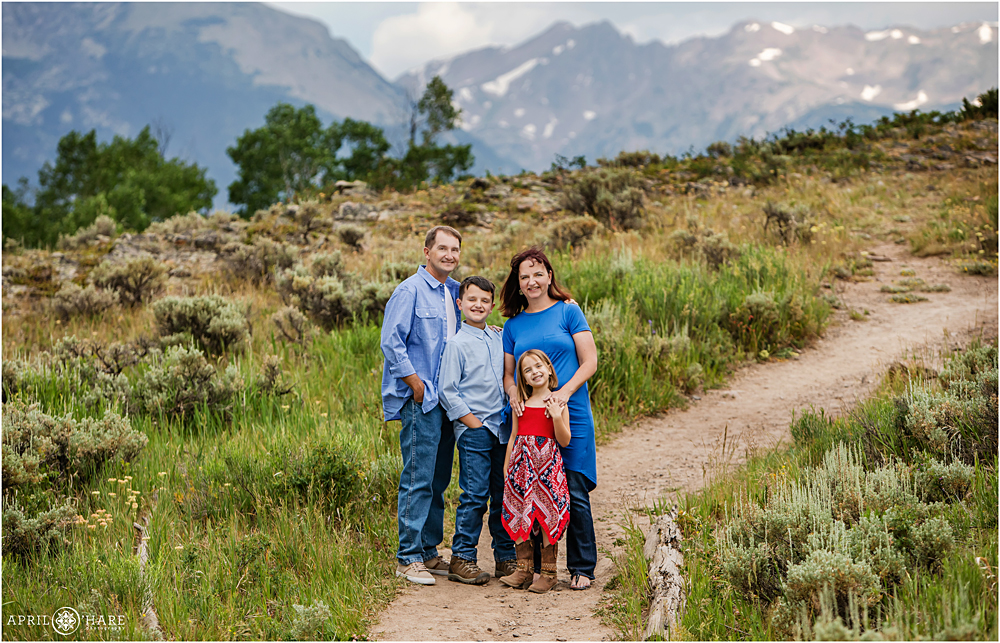 A family poses for a photo on a dirt hiking trail near the Prospector Campground entrance at Lake Dillon in CO