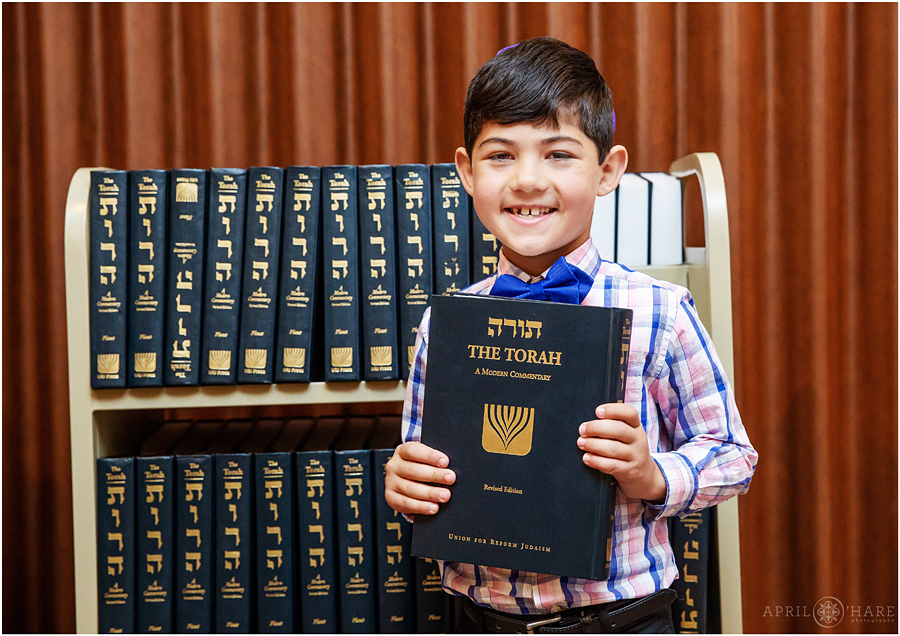 Young boy hands out prayer books prior to a Temple Emanuel Bat Mitzvah Celebration in Denver Colorado