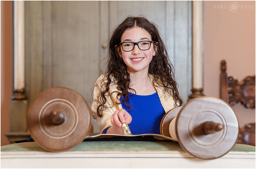 Young lady poses with the torah for portraits at her Temple Emanuel Bat Mitzvah Service in Denver Colorado