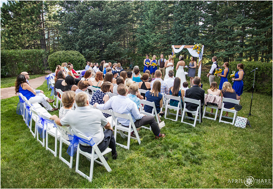 Wedding ceremony on the grass for a pretty Backyard Lesbian Wedding in the Mountains of Colorado