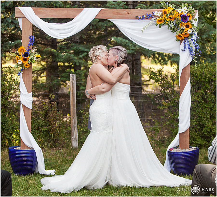 Two Brides Kiss at their wedding ceremony at their Backyard Lesbian Wedding in Colorado