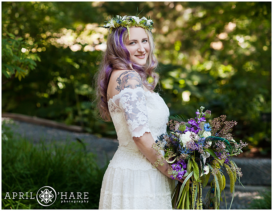 Beautiful offbeat bohemian bride wearing off the shoulder wedding gown and flower crown