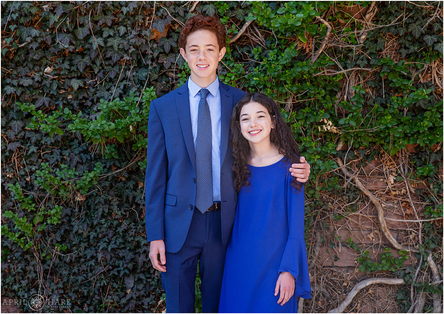 A Temple Emanuel Bat Mitzvah girl poses for a portrait with her big brother in the courtyard in Denver Colorado