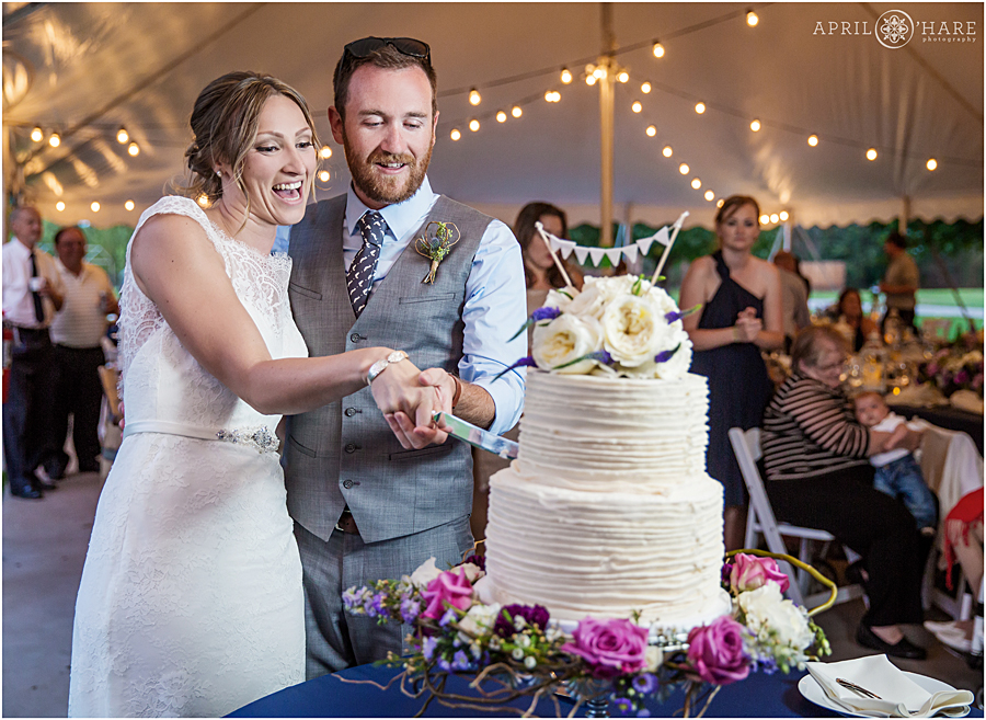 Couple cuts their cake at Deer Creek Stables Chatfield Farms Wedding during summer