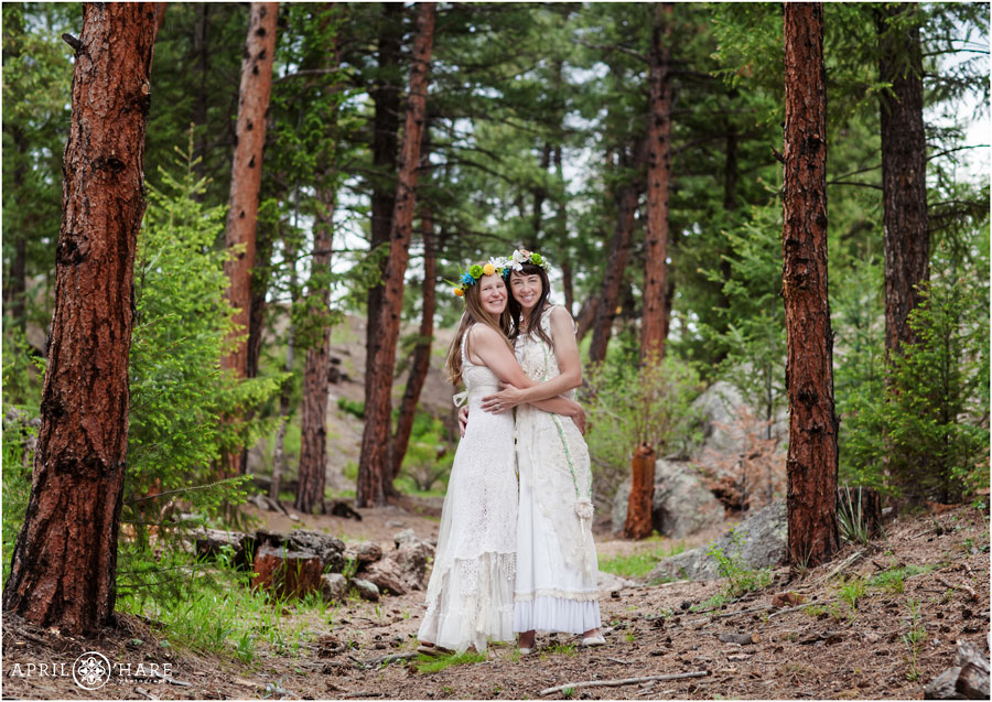 Bohemian brides at their Colorado Lesbian Elopement wearing flower crowns and lace hippie dresses in the woods of Pine CO