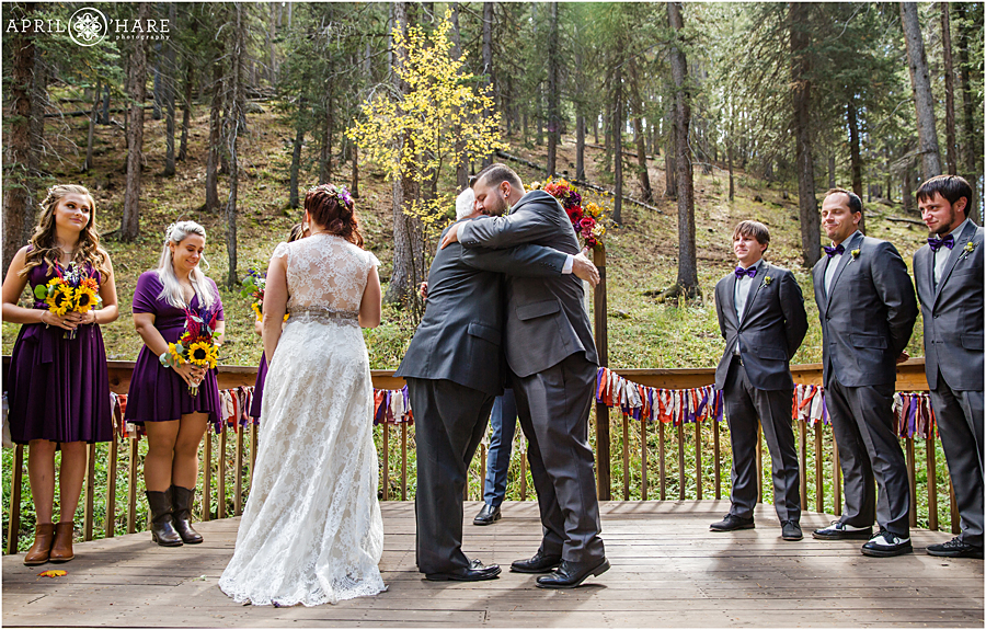 Pretty outdoor Colorado Boho Wedding in the forest with ribbon garland and fall color floral arch