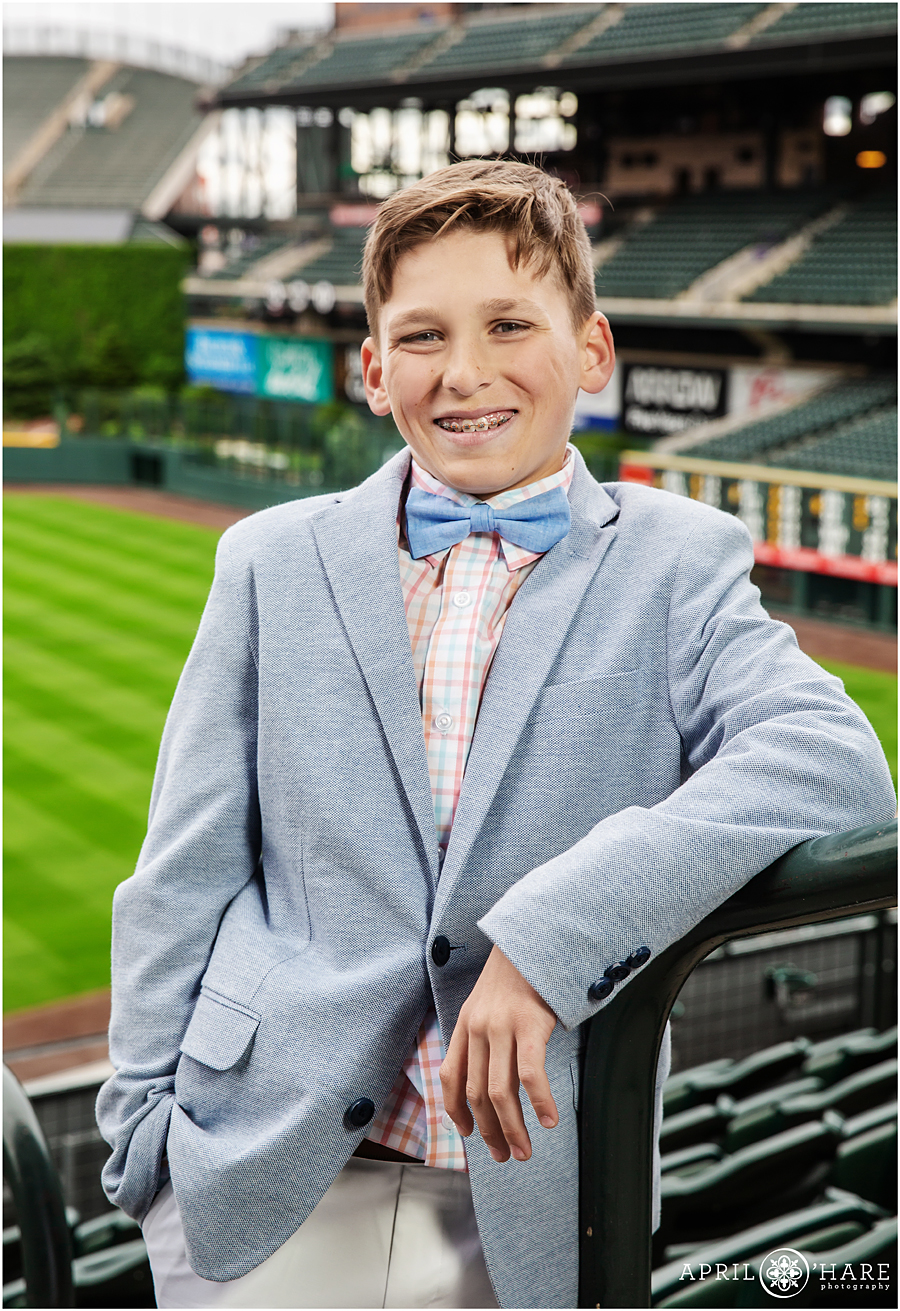 Portrait of the bar mitzvah boy in his bow tie and suit jacket at his baseball themed bar mitzvah at Coors Field in Denver
