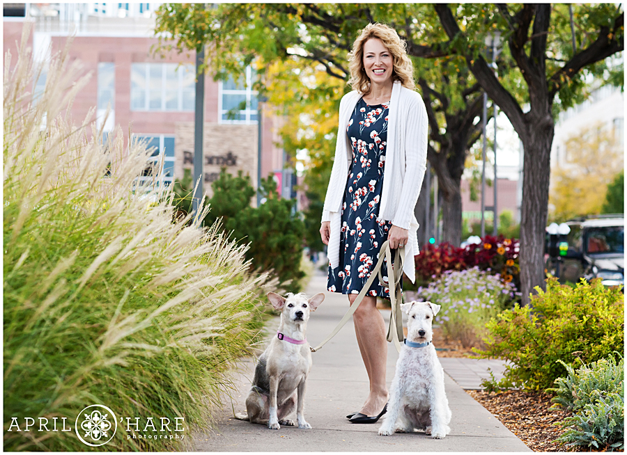 Beautiful woman walks her two cute dogs during her lifestyle Cherry Creek headshots