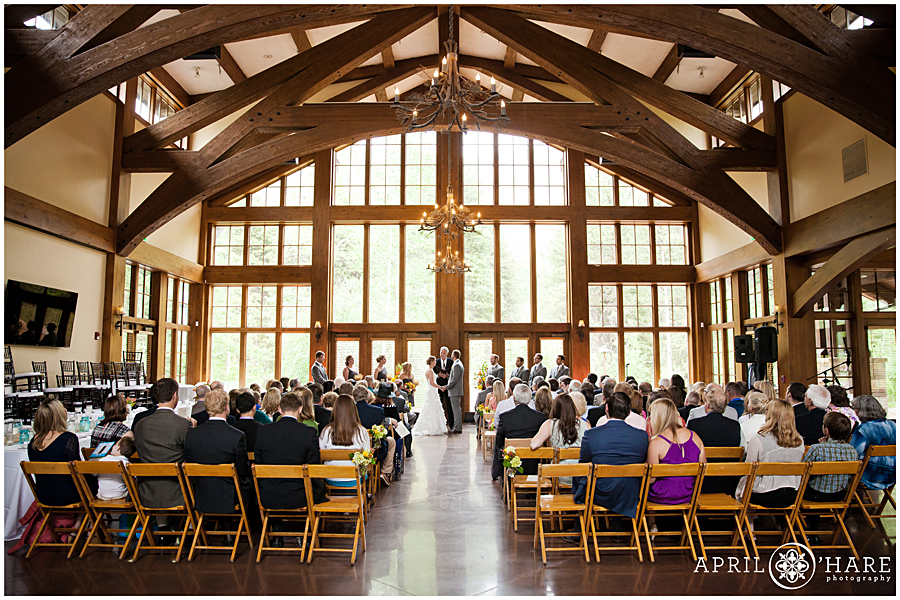 Beautiful indoor Vail wedding ceremony with huge window backdrop at Donovan Pavilion