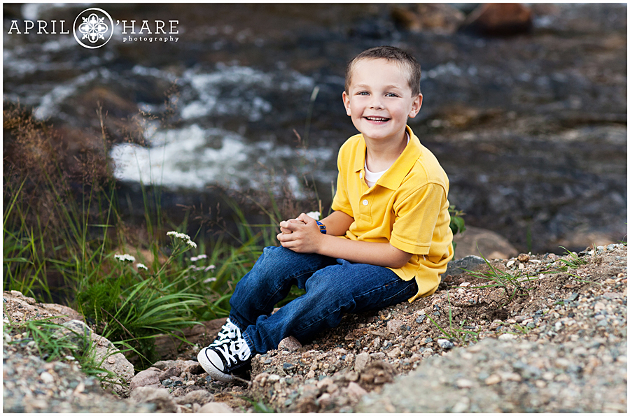 Adorable boy in a yellow polo shirt with Bear Creek backdrop at Evergreen Lake House Family Photos