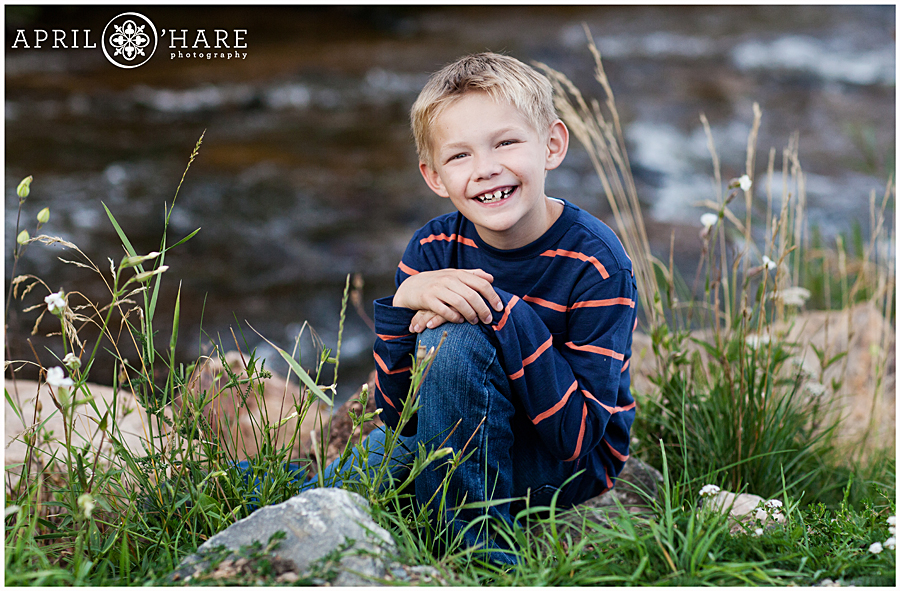 Smiling young boy with Bear Creek backdrop at Evergreen Lake House Family Photos