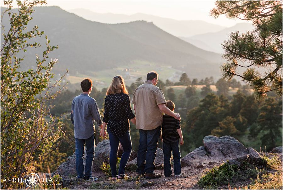 Sweet photo of a family holding hands as they look out at the sunset views at their Mount Falcon Family Photos
