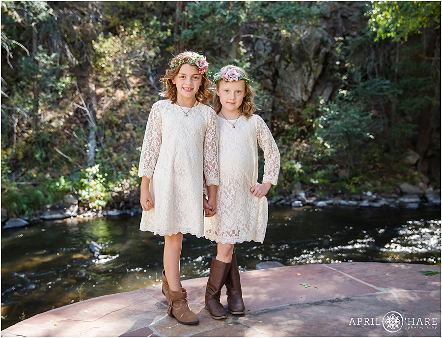 Cute flower girls wearing flower crowns, lace dresses, and boots at a pretty Colorado Boho Wedding