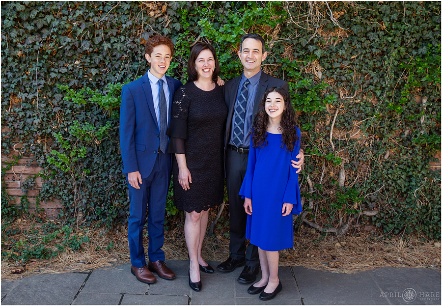 A family of four pose for formal portraits in the courtyard at a Temple Emanuel Bat Mitzvah in Denver 