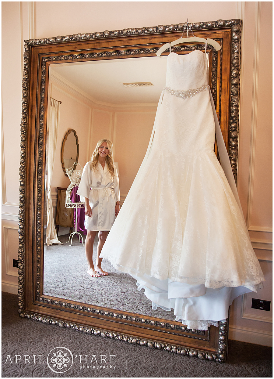 Huge fancy mirror with wedding dress hanging from it at a Denver Winter Mansion Wedding