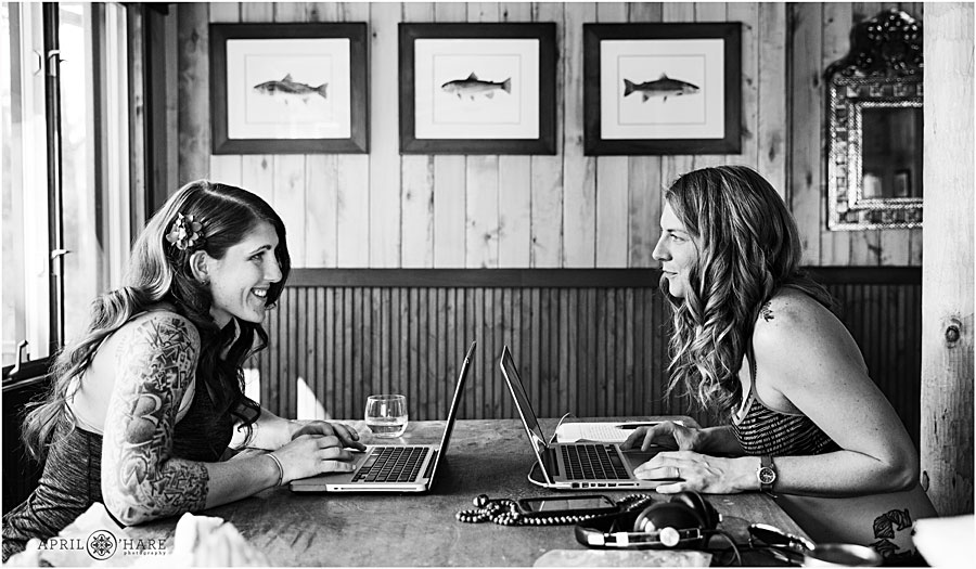 Cute photo of two brides on their laptops before their Colorado Lesbian Wedding