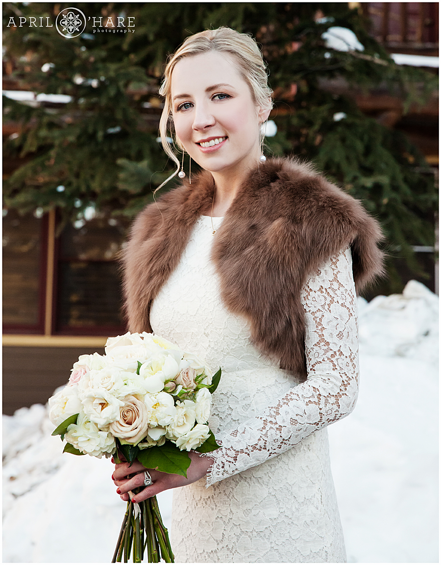 Beautiful bride wearing long sleeved dress at her Winter Wedding in Breckenridge