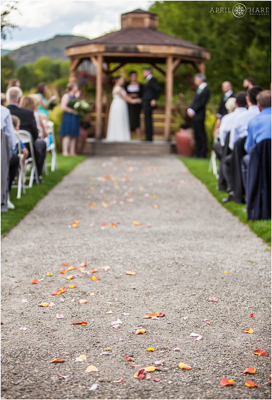 Petals adorn the outdoor gravel path at rustic Colorado wedding venue Chatfield Farms