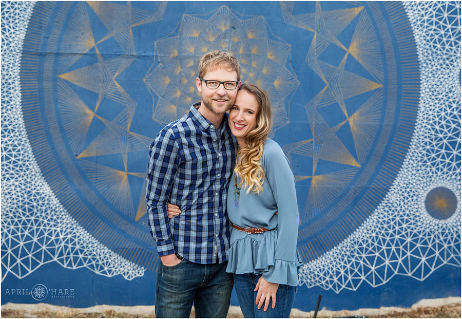 Cute engagement picture with blue mural backdrop along Cherry Creek Bike Path