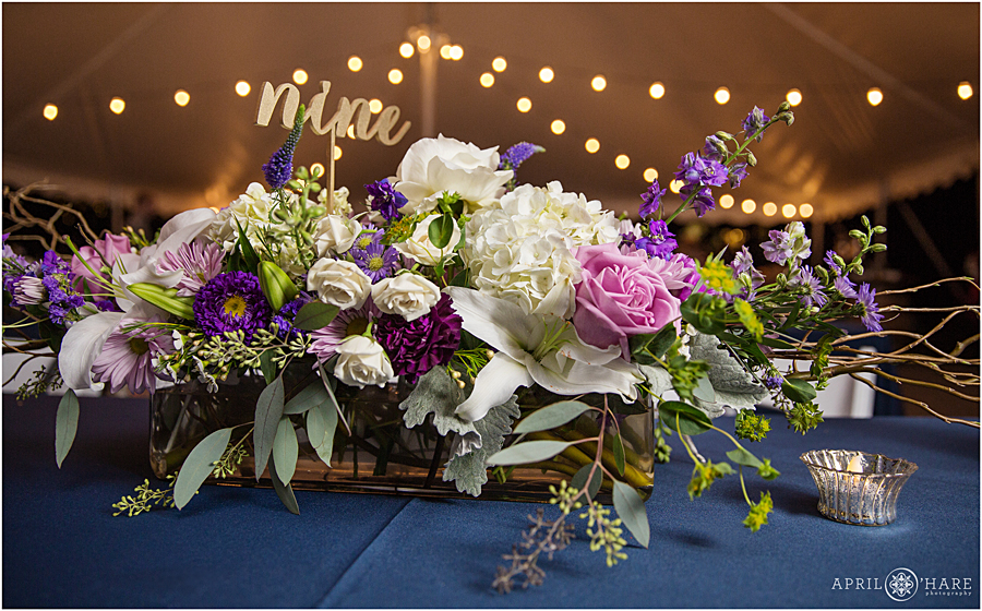 Beautiful pink and purple floral table centerpiece in Deer Creek Stables Wedding Reception at Chatfield Farms
