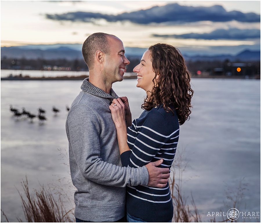 Denver Winter Engagement Photography with geese walking across frozen Sloans Lake in backdrop