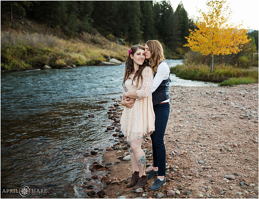 Romantic photo of two brides at their Colorado Lesbian Wedding next to a mountain stream
