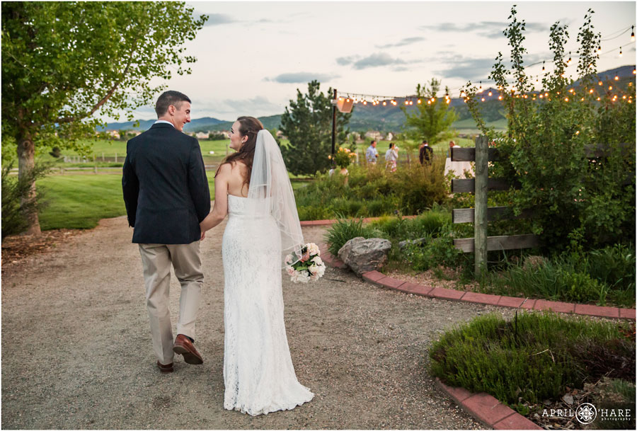 Bride and Groom Walk Hand in Hand to their wedding reception at Chatfield Farms 