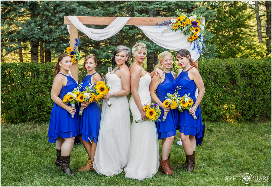 Adorable Backyard Lesbian Wedding with bridesmaids wearing bright blue and yellow sunflowers