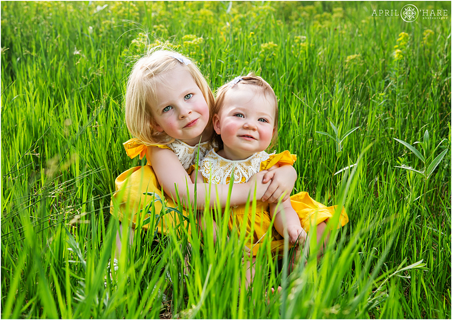 Cute sisters photo in the grass at Bluff Lake State park created by a Stapleton Family Photographer