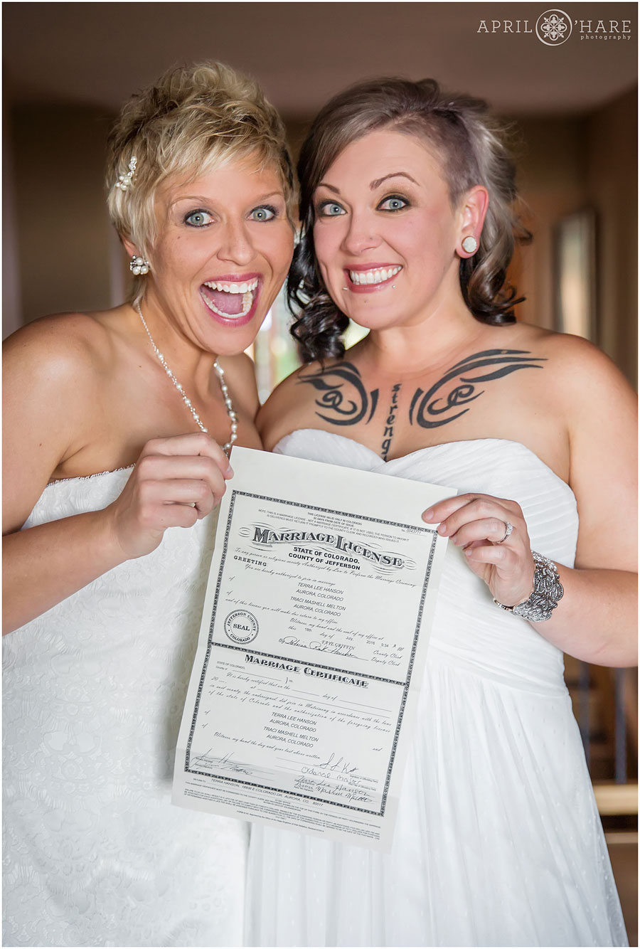 Adorable photo of two excited brides holding their marriage license at their Backyard Lesbian Wedding