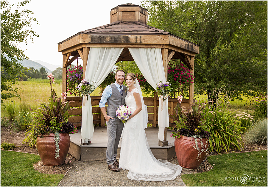 Beautiful portrait of wedding couple posing for formal portrait in front of the gazebo on their Deer Creek Stables wedding at Chatfield Farms