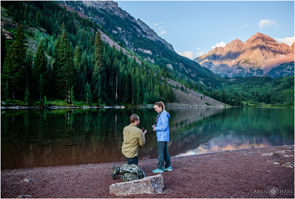 A young man proposes to his girlfriend at Maroon Bells in Aspen at Sunrise
