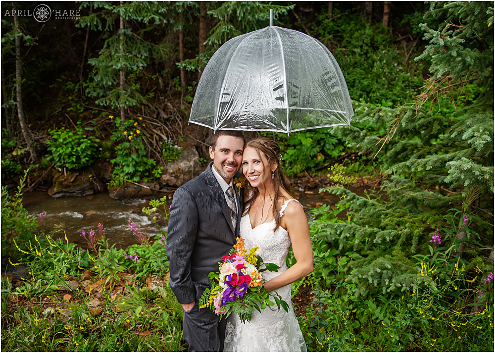 Rainy wedding day portrait with umbrella and wildflowers at Blackstone Rivers Ranch
