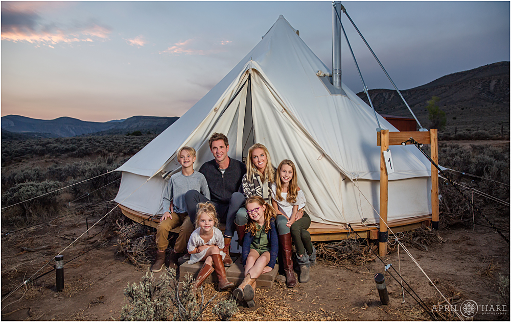 Family next to their canvas glamping tent 