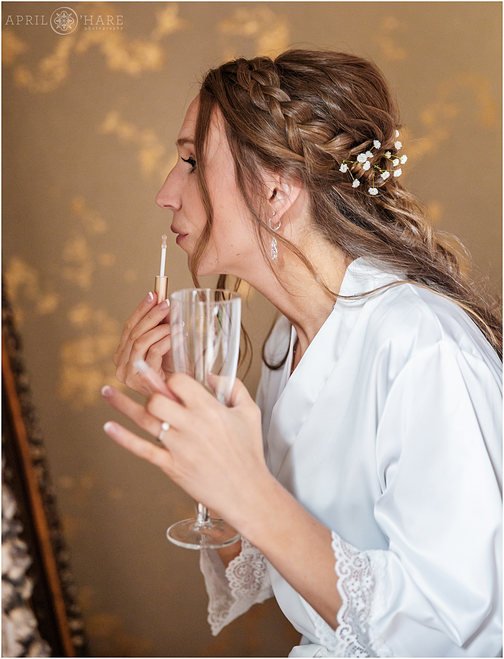 Bride applies lip gloss in the bridal suite at Blackstone Rivers Ranch 
