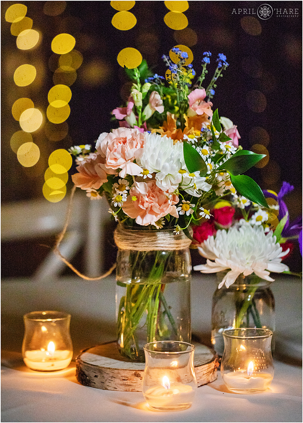 Detail photo of a floral centerpiece with candles from a rustic mountain wedding at Blackstone Rivers Ranch in Colorado
