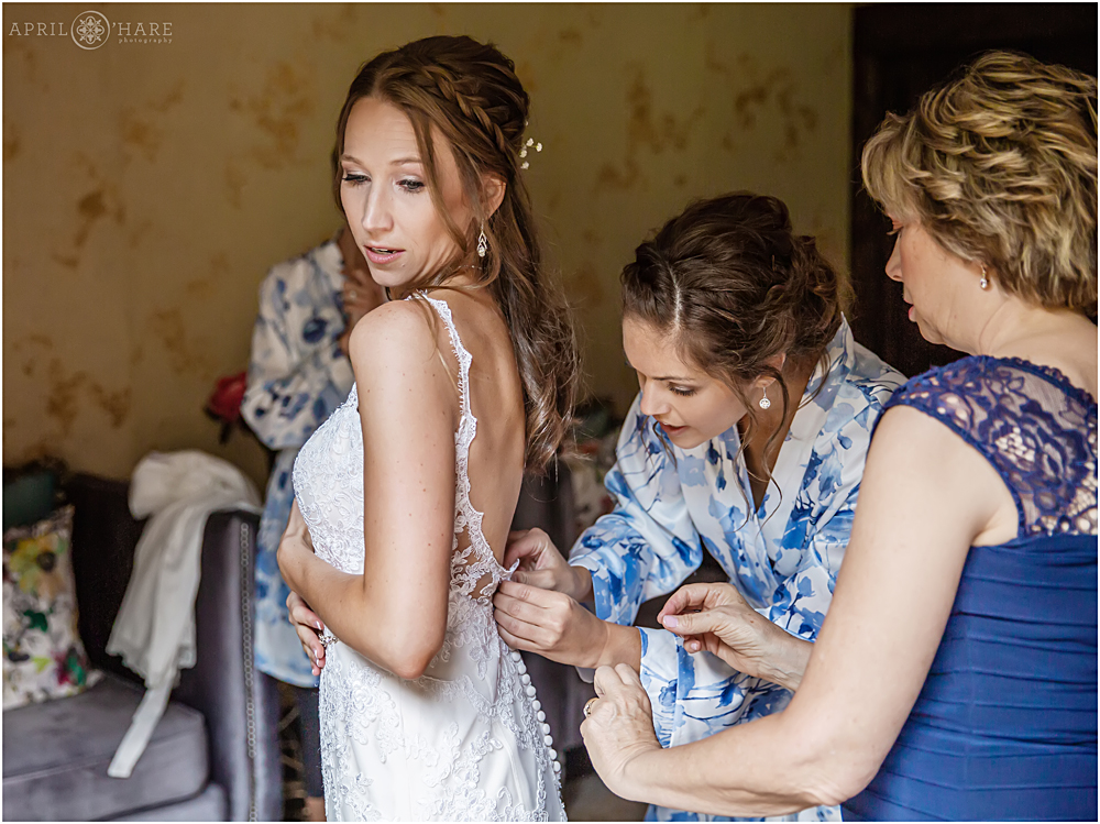 Bride gets some help with her dress at Blackstone Rivers Ranch in Colorado