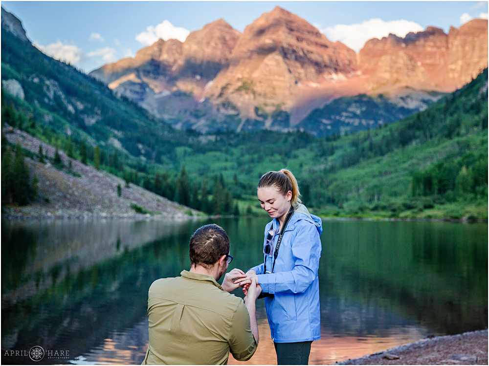 A surprised girl gets an engagement ring during her sunrise wedding proposal  at Maroon Bells in Aspen