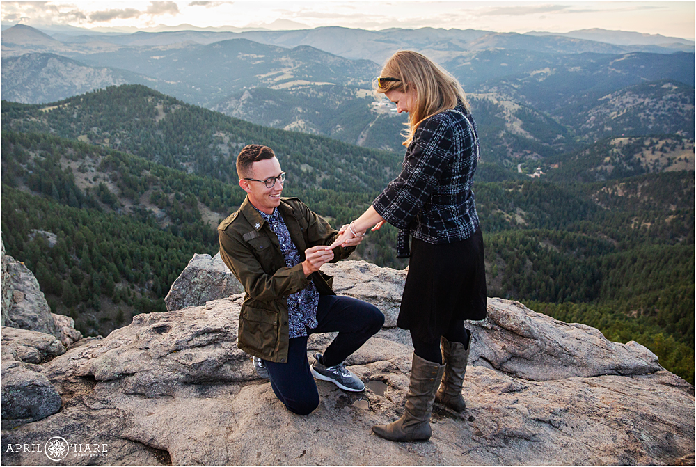 Man proposes to girlfriend with mountain backdrop at sunset Lost Gulch overlook in Boulder