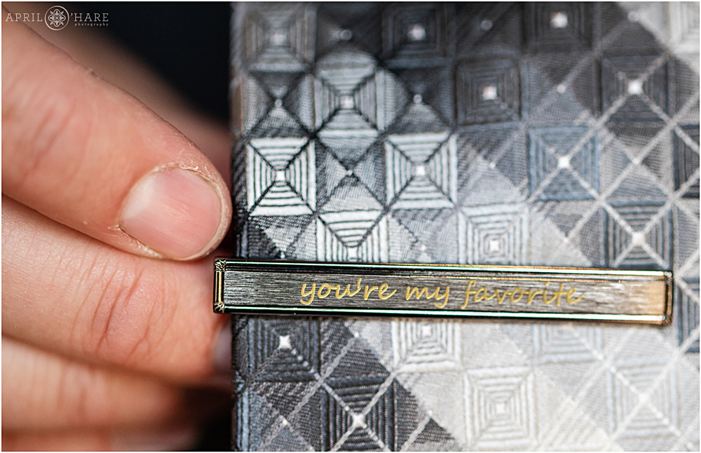 Custom tie clip with an engraved message on it at a CO mountain wedding