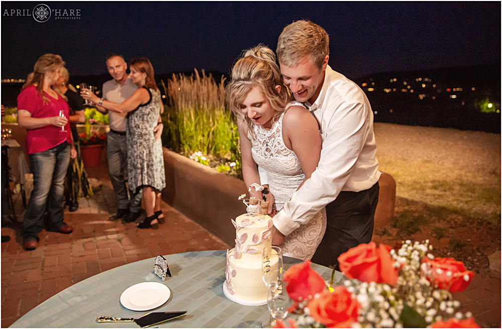 Newlyweds cut their cake at their intimate wedding dinner at The Fort