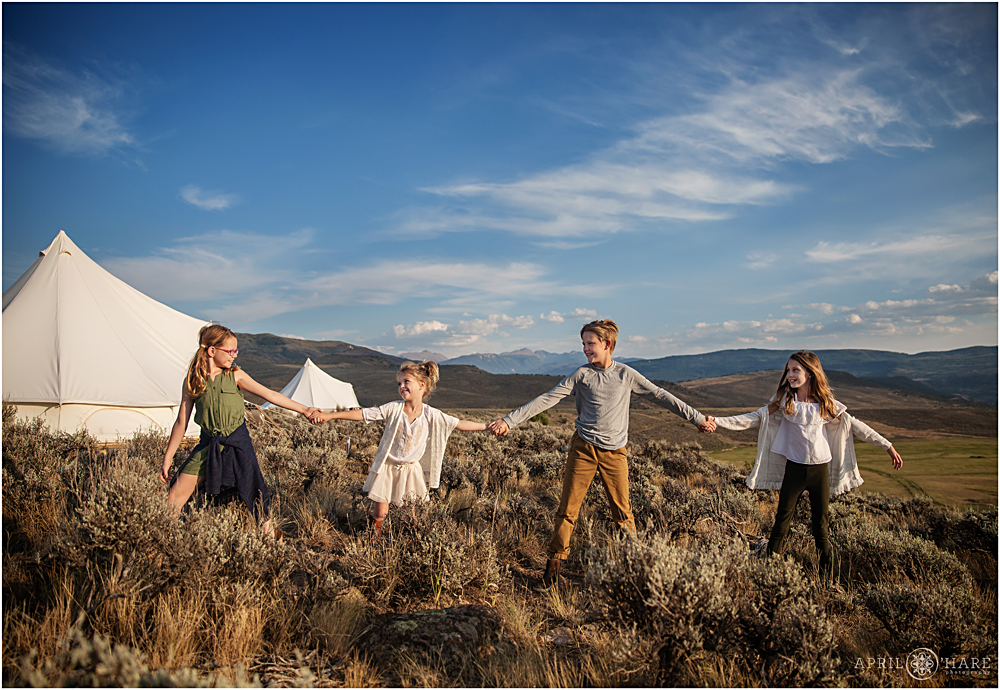 Siblings have fun under wide open blue sky of Colorado