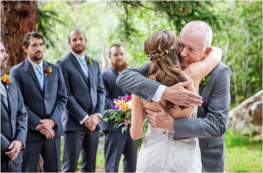 Bride and dad hug during wedding ceremony at Blackstone Rivers Ranch